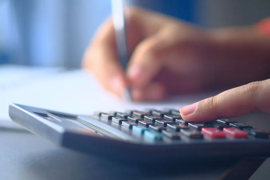 A printable budget tracker sheet with a pen and calculator