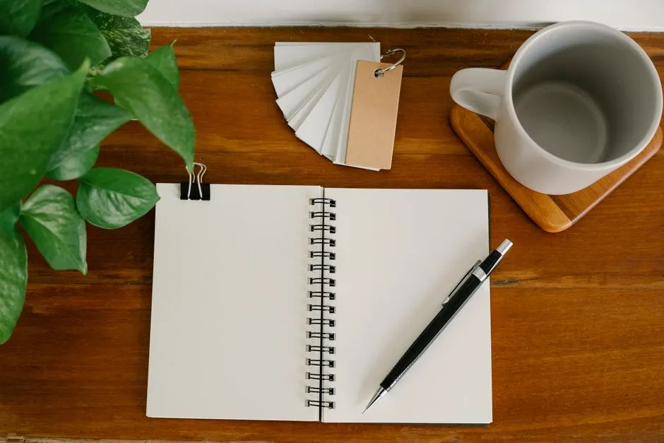 A cup of coffee beside an open daily planner in the morning